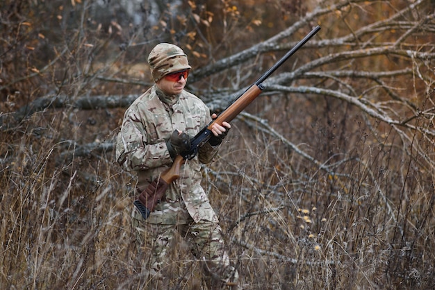 Hunter in uniform with a hunting rifle
