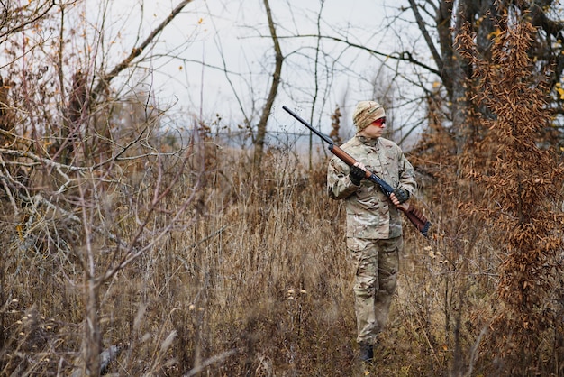 Hunter in uniform with a hunting rifle