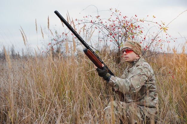 Hunter in uniform with a hunting rifle