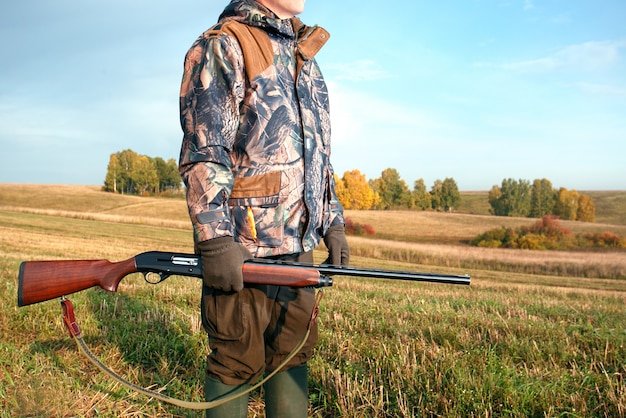 秋に銃を持つハンター。秋の狩猟シーズンのハンター。