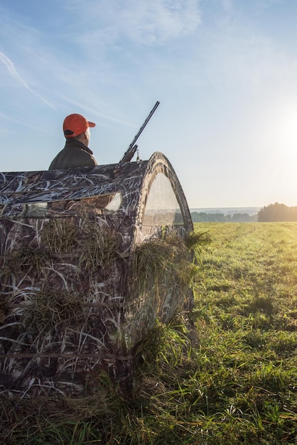 Hunter with gun in the nature