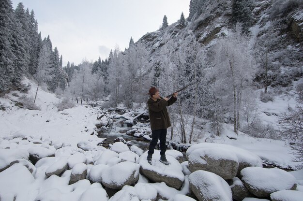 hunter with a gun in the winter mountains