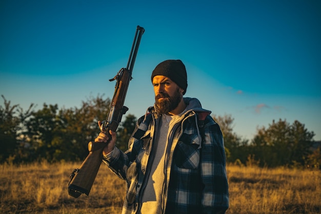 사냥에 엽총 총을 가진 사냥꾼 수염된 사냥꾼 남자 총을 들고 숲에서 산책
