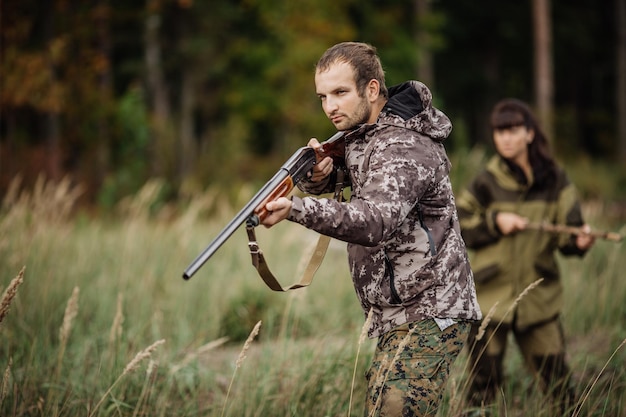 Фото Охотники в камуфляжной одежде готовы к охоте с охотничьим ружьем
