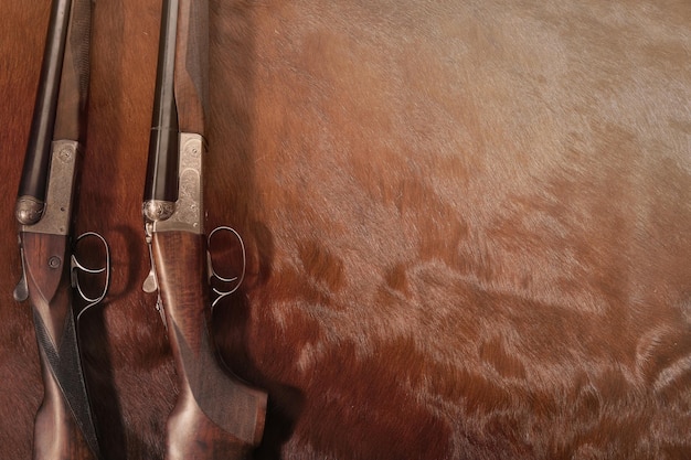 Hunting concept with two shotgun arranged on brown background