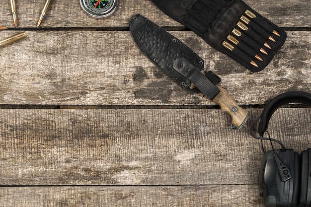 Hunting equipment on old dark wooden background