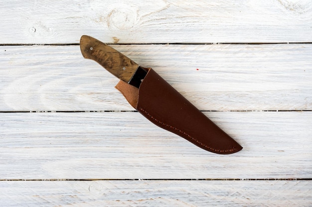 Foto coltello da caccia in involucro di pelle coltello di caccia su legno withe