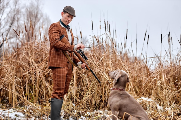 Foto periodo di caccia stagione autunnale aperto americano n maschio in abito marrone bracconiere impartire comandi addestrando il d