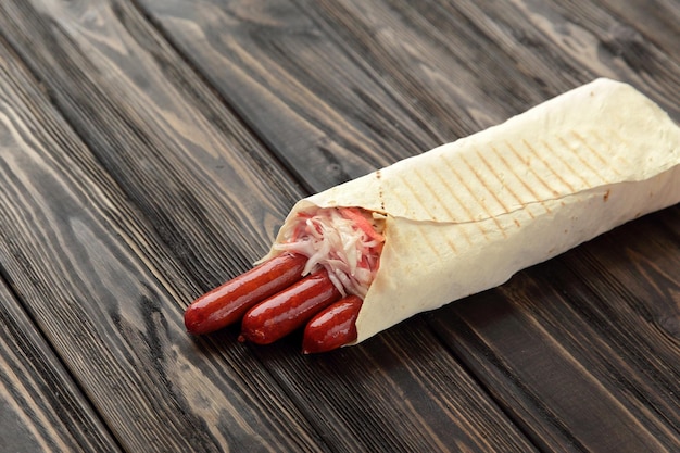 Hunting sausages in pita bread on a dark wooden background