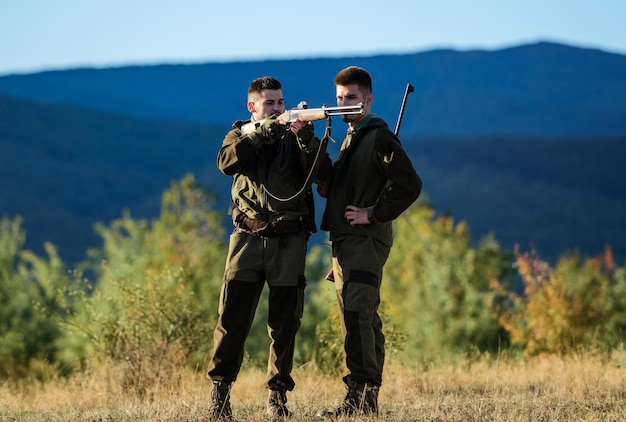 Foto abilità di caccia e equipaggiamento delle armi come trasformare la caccia in un hobby amicizia tra uomini cacciatori forze dell'esercito mimetizzazione moda uniforme militare cacciatori con fucile campo di addestramento maschio con una pistola