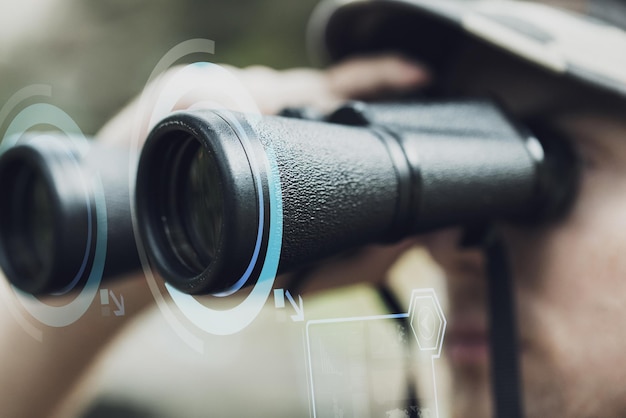 hunting, war, army and people concept - close up of young soldier looking to binocular with virtual hologram and observing forest