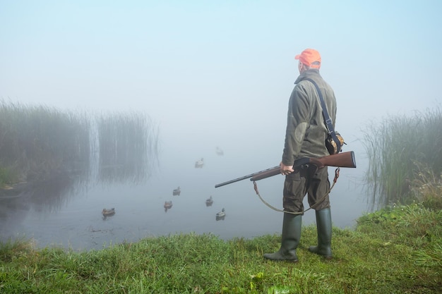 Hunting with ducks decoy on lake man out hunting