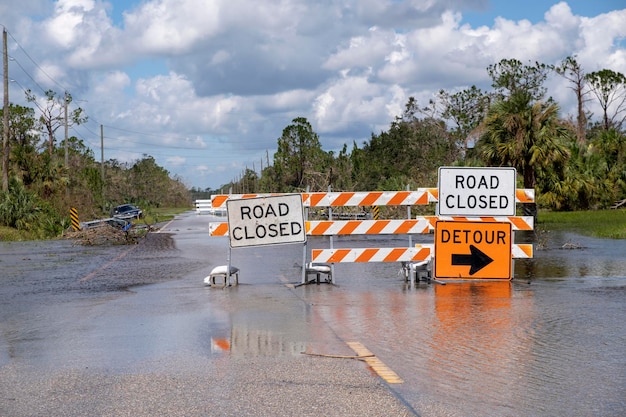 Hurricane flooded street with road closed signs blocking driving of cars Safety of transportation during natural disaster concept