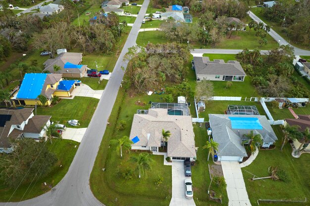 ハリケーン・イアンにより被害を受けた家屋の屋根は雨水を防ぐプラスチック製の防水シートで覆われ、アスファルト帯状疱疹の交換まで雨水が漏れる自然災害の余波