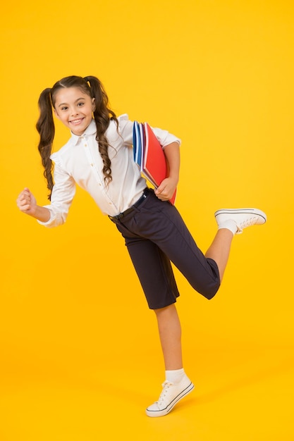 Hurry up Girl with books on way to school Knowledge day Back to school Kid cheerful schoolgirl running Pupil want study Active child in motion Beginning school lesson Keep going Active kid