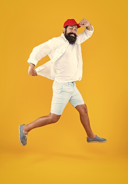 Photo hurrying man deliveryman isolated on yellow hurrying man deliveryman in studio hurrying man deliveryman on background photo of hurrying man deliveryman jumping