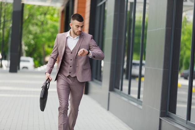 Hurrying to work. Full length of young businessman looking forward while running along the street