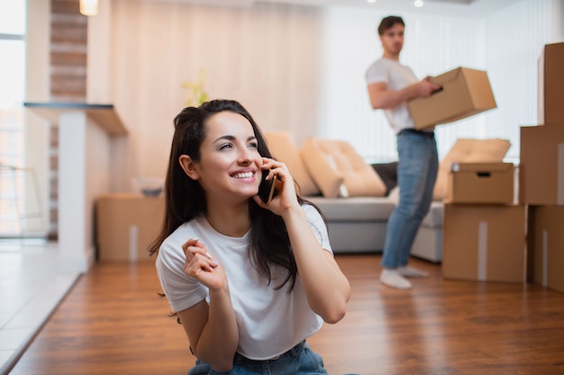 husband carries boxes, and the wife speaks on the phone