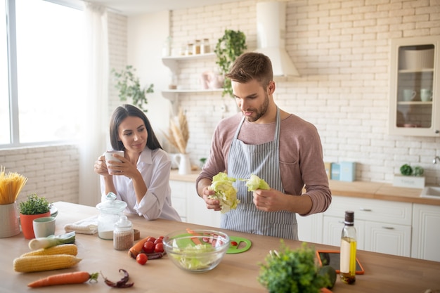 Husband cooking Wife wearing white shirt coming to husband cooking in the morning