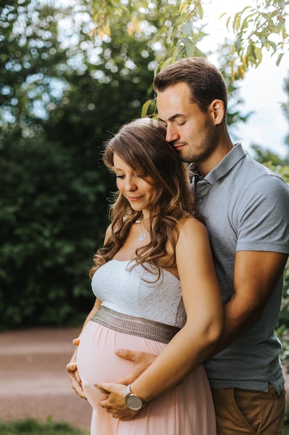 妊娠中の妻を外で抱きしめる夫