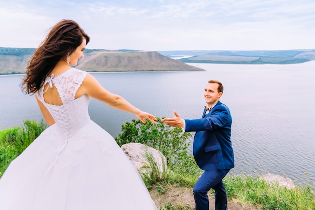 Husband giving a hand to his wife in wedding dress