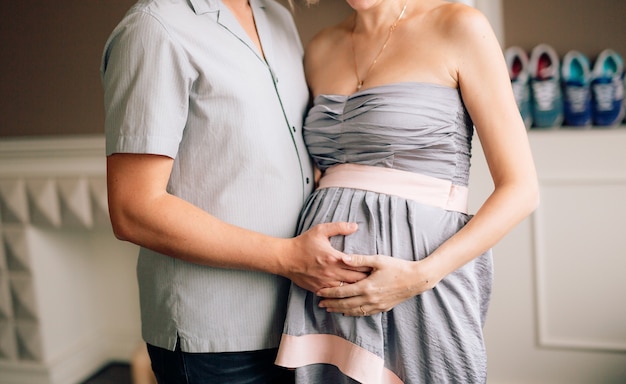 Husband hugging pregnant wife hands of a man on a womans belly