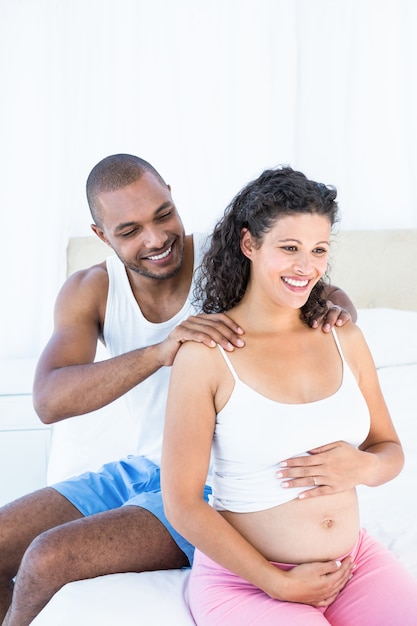 Husband massaging pregnant wife shoulders