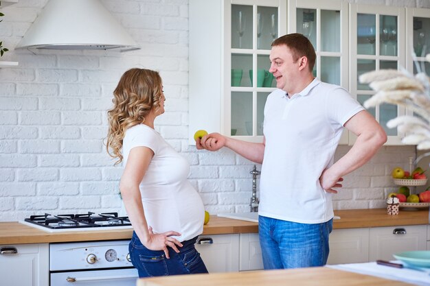 Husband offers an apple to his pregnant wife.