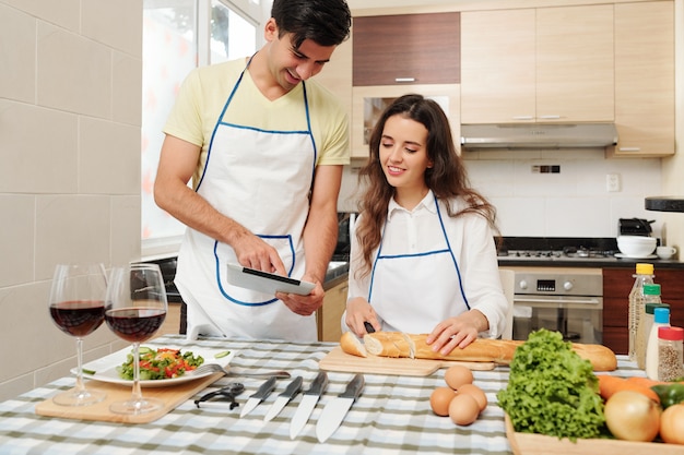 Husband showing her recipe to cooking wife