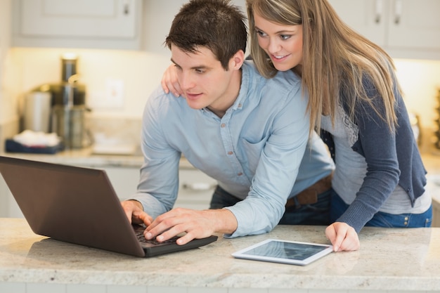 Husband surfing internet while wife is looking on 