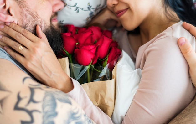 Photo husband surprised wife with red rose bouquet