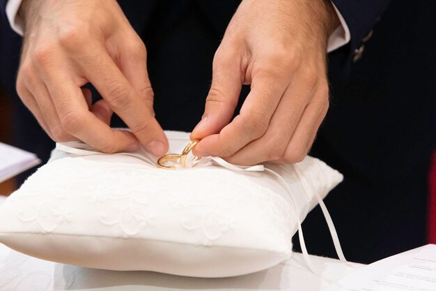 Husband taking the wedding ring to put it on the finger of the future wife