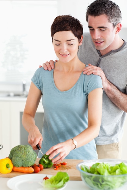 Husband watching his wife cutting vegetables