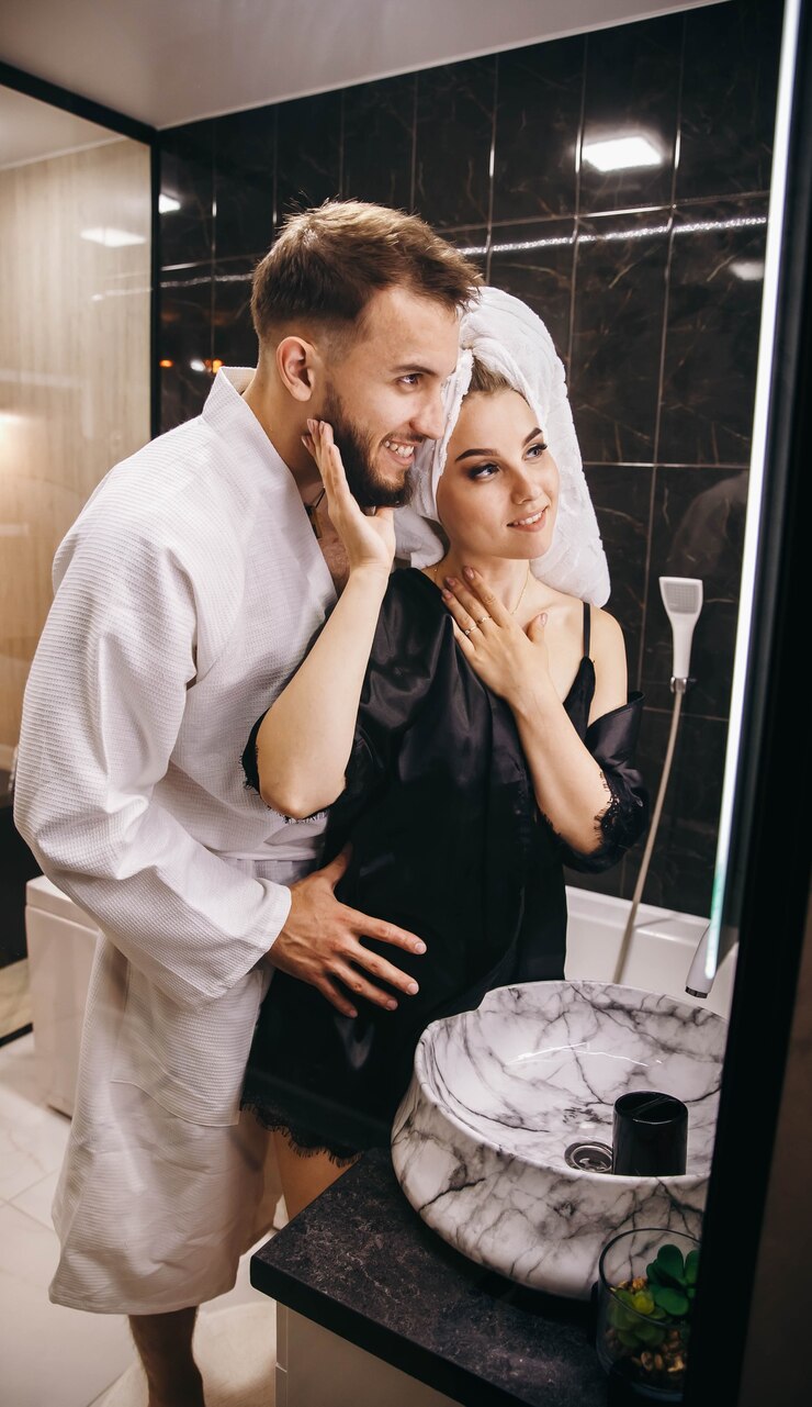 Husband and wife in the bathroom fooling around in front of the mirror