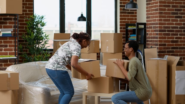 Husband and wife carrying home belongings for relocation, moving in new rented property together. Real estate apartment to move in and start new beginnings as homeowners family.