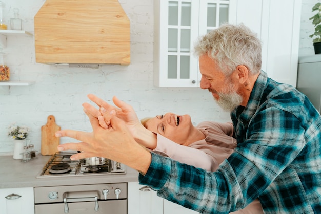 Husband and wife dance in the kitchen during breakfast