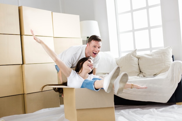 husband and wife have fun unpacking boxes in their new apartment