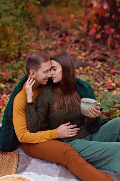 Husband and wife hug each other at picnic in nature