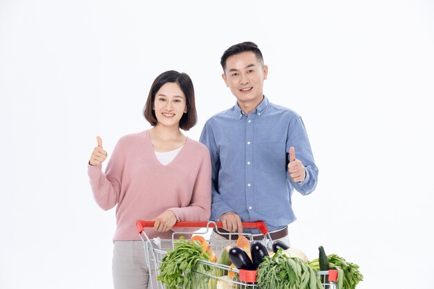 Photo husband and wife shopping for vegetables at the supermarket