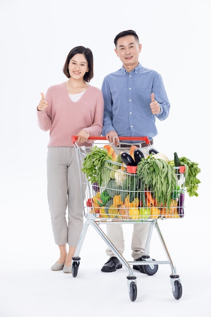 Муж и жена покупают овощи в супермаркете