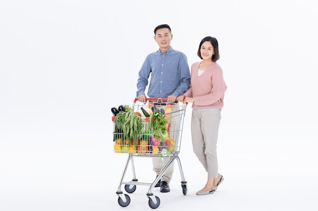 Photo husband and wife shopping for vegetables at the supermarket