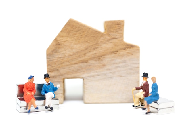  Husband and wife sitting in front of house on white background