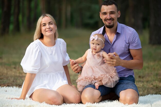 Husband wife and their little daughter for a walk in the park