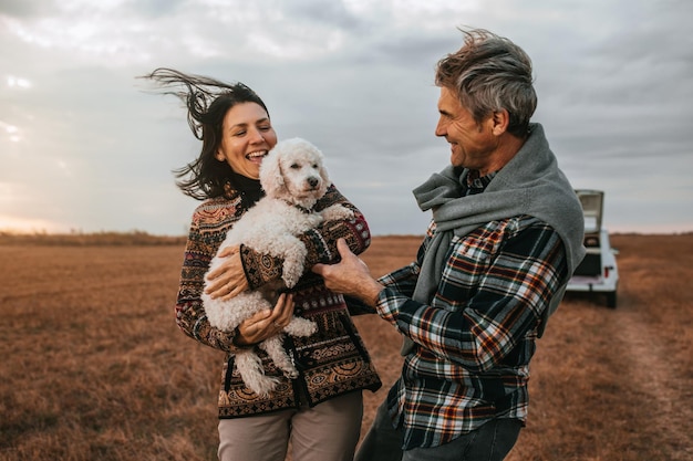 Photo husband and wife with their dog at picnic