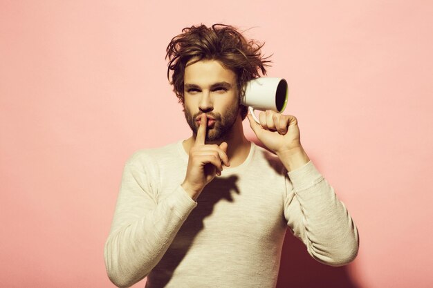 Photo hush gesture of man overhear with cup