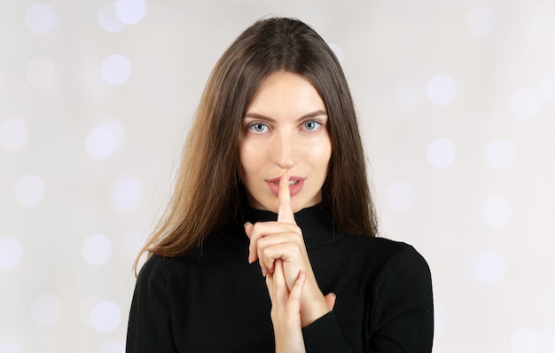 Foto silenzio. donna che chiede il silenzio o il segreto con il dito sulle labbra shh gesto della mano