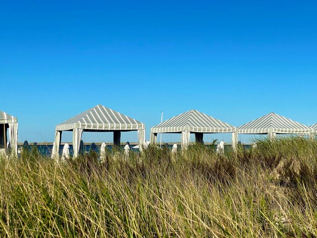 Huts on beach against clear blue sky