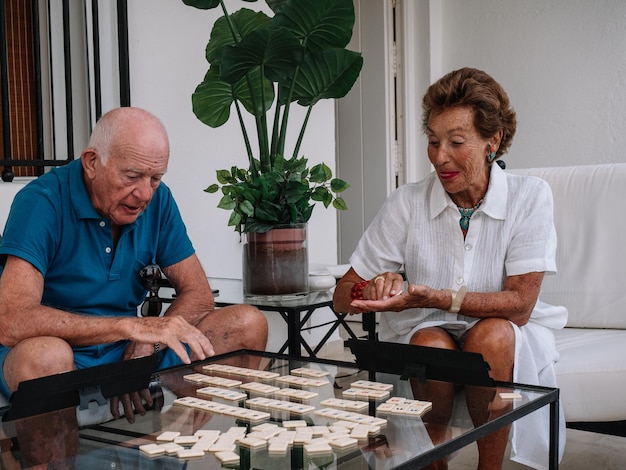 Huwelijk achttigjarige speelt levendig aan een bordspel dat bestaat uit het maken van combinaties van getallen