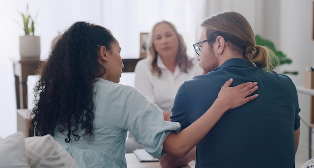 Huwelijksbegeleiding en koppel in therapeutenkantoor troostzorg geven en praten met partner Man en zwarte vrouw met maatschappelijk werker of psycholoog voor probleemondersteuning en hulp in relatie