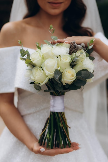 Huwelijksboeket in de handen van de bruid mooie huwelijksbloemen